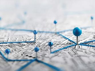Up close photograph on a map with pins stuck on it
